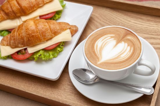 Croissant alongside cup of coffee