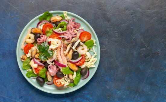 Seafood with vegetables in a plate on the table. Top View