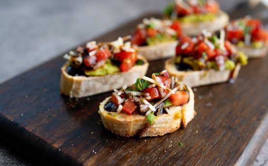 Bruschetta Sandwich served as an appetiser with tomato, avacado, onion and balsamic glaze